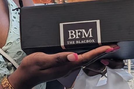 A subscriber holding her Black-owned subscription box at a community pop-up