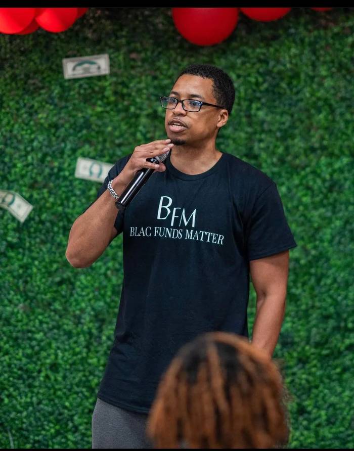 The founder of 1 Trill Project speaking at a community event about circulating the Black dollar